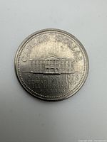 Reverse of 1973 PEI commemorative dollar showing Province House design and bilingual dates