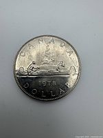 Reverse side of 1978 Voyageur dollar showing canoe scene, date and legends