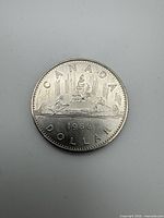 Reverse of 1986 Canadian Voyageur dollar showing canoe design and date