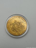 Obverse of gold-tone commemorative dollar showing London Bridge, sailing ship, dates and Celebrate the Vision inscription