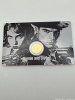 Front view of encapsulated 1/1000 oz gold coin in themed Bonnie and Clyde display card