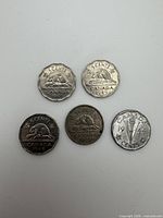 Reverse of five coins showing dates and designs (beaver and Victory ‘V’)