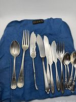 Utensils laid out on blue Birks roll showing all pieces and patterns