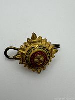 Front view showing starburst shape, enamel circlet, crowns, laurel detailing