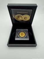 open presentation box showing coin in capsule and certificate
