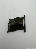 Reverse of badge with double prong attachment and maker mark