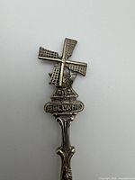 Close-up of windmill finial showing rotating blades and embossed "Holland" text