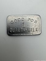 Front of aluminum token showing GOOD FOR 1 QUART OF MILK text