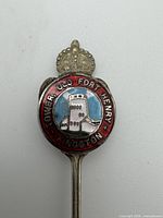 Close-up of enamel crest showing fort tower graphic and surrounding text