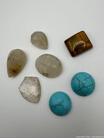 Seven assorted gemstones laid out showing shapes and colors