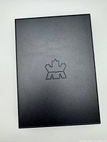 Matte black outer slipcase featuring embossed maple-leaf logo