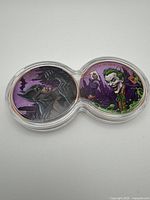 Dual capsule holding both copper rounds, Batman left, Joker right