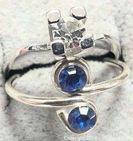 Stacked view of both silver rings showing clear cubic zirconia ring atop blue stone bypass ring