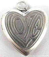 Front view of silver heart locket showing embossed LOVE design and bail