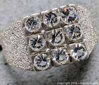 Top view of silver ring showing 3x3 grid of cubic zirconia stones