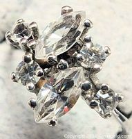 Close-up of ring showing marquise and round CZ stones in prong settings on silver band