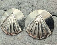 Front view of both round silver earrings showing raised fan shell design