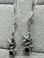 Frontal view of both earrings showing bird motif, black stones and ear wires