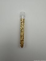 Full view of capped plastic vial filled with gold flakes