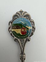 Close-up of enamel finial showing gondola scene and text