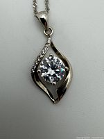 Close-up of sterling silver pendant and portion of chain showing large central stone and accent stones