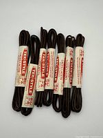Eight wrapped brown Tex-Style shoelaces shown, part of the total 12 pieces