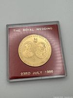 Front of medallion in case showing portraits and date