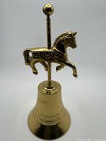 Full view of brass bell with horse figure front perspective