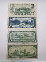 Backs of four vintage Canadian banknotes ($1 and $5) laid out vertically