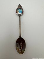 Full view of souvenir spoon showing enamel crest and etched bowl