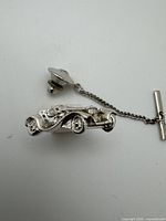 Front view of sterling silver car tie tack with attached chain and clutch back