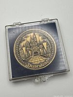 Front of medallion showing castle and Disneyland text in holder