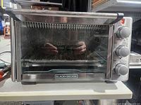 Front view of Black+Decker toaster oven showing glass door and control knobs