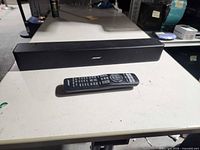 Front view of Bose soundbar and remote on table