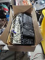 Top view of box showing stacked keyboards and cables