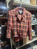 Front view of Carlisle multicolor tweed jacket on hanger with matching scarf visible below