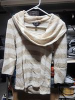Front view of striped Dusak Designs sweater on hanger