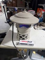 Front view of DynaTrap mosquito trap with power cord and boxed spare bulb