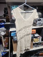 Full view of ivory crochet dress on hanger