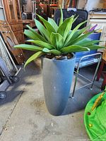 Full view of artificial plant in tall grey planter