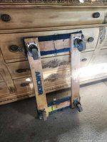 Full view of dolly leaning against dresser showing wheels and frame