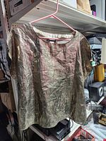 Front view of metallic gold top on hanger