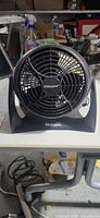 Front view of Holmes black desk fan showing grille and logo