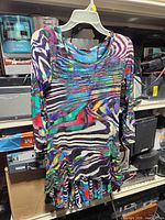 Full view of blouse on hanger showing pattern, sleeves, hem