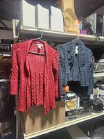 Front view of both sweaters hanging side by side