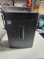 front view of black paper shredder showing viewing window and label