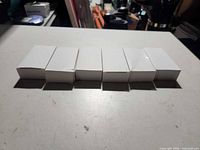 Six small white product boxes lined up