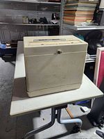 Closed portable computer viewed from rear/side showing carry handle and overall case condition