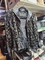 Front view of black and silver rose patterned jacket hanging on hanger