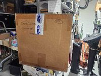 Closed carton labeled “Shoe Covers Universal 100/pk” with circled 32